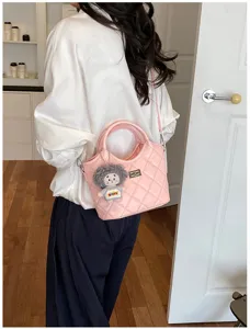 Sac bandoulière matelassé rose avec poignée, fermoir tourniquet en métal et joli pendentif poupée.