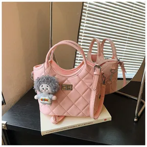 Sac à main matelassé rose avec pendentif poupée en peluche, sac seau tendance pour femmes.