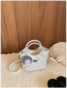 Sac à main seau matelassé chic avec charm poupée en peluche, élégant sac bandoulière pour femme.