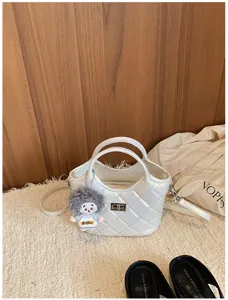 Sac seau matelassé blanc avec poignées, bandoulière et charmant pendentif poupée en peluche.