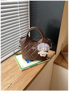 Sac à main matelassé marron foncé avec poignées et pendentif poupée mignon, sac bandoulière rétro.