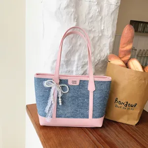 Blue denim tote bag with pink leather trim, pearl lace pendant, chic casual shoulder bag.