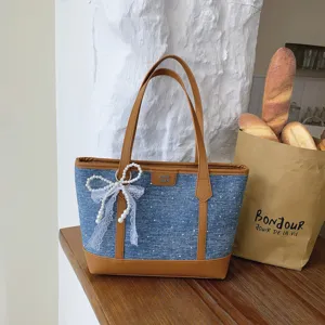 Casual denim tote bag for women, stylish patchwork shoulder bag with pearl bow detail.