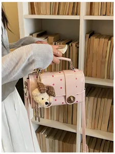 Chic pink polka dot crossbody bag with cute teddy bear pendant, versatile summer handbag for women.