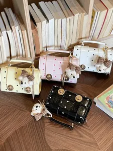 Chic polka dot crossbody bag for women with cute bear pendant, stylish summer handbag.