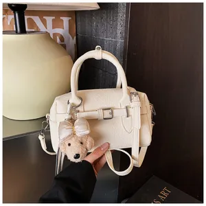 Chic borsa a mano Boston in pelle bianca con simpatico portachiavi orsetto e tracolla.