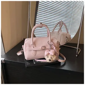 Borsa a tracolla Boston rosa con grazioso ciondolo ad orsetto e dettaglio cintura.