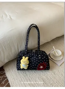 Gros plan détaillé du sac Boston élégant à motifs de pattes avec pendentif lapin en peluche.