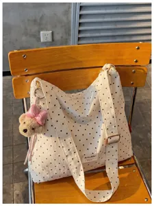 Vue détaillée du grand sac cabas en toile à pois avec son joli pendentif d'ours en peluche.