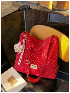Grand sac cabas chic à pois rouges avec pendentif ours pour vos trajets quotidiens.