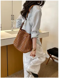 Bruine geweven emmertas stijlvolle lederen crossbody tas vintage uitgeholde schoudertas vrouwen