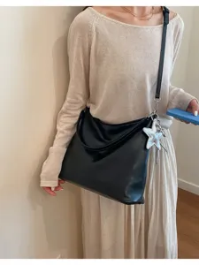Casual black slouchy shoulder bag for women, elegant hobo tote with cute star charm accessory.