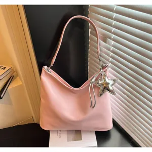 Detailed view of trendy pink shoulder tote bag with cute silver star pendant for women.