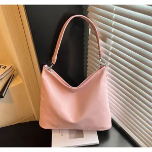 Detailed view of the pink minimalist shoulder bag, showing smooth leather texture and hardware.