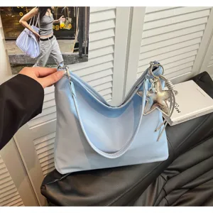 Light blue minimalist tote bag with silver star pendant, casual chic shoulder bag style.