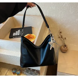 Black PU leather shoulder bag for women, chic hobo tote with star charm and strap.