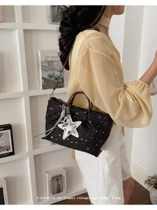 Versatile women's tote bag with star pattern, brown handles, and stylish silver star pendant.