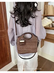 Vintage woven bucket shoulder bag with mini charm for women stylish casual daily use.