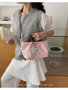 Stylish pink star print tote bag with large star charm, versatile shoulder and crossbody design.
