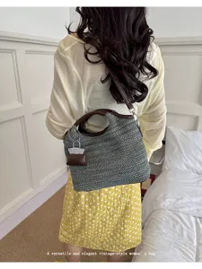 Detailed view of women's woven shoulder bag, stylish casual handbag with brown handles.