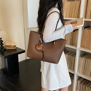 Large capacity brown leather tote bag for women, stylish shoulder bag with cute bear charm.