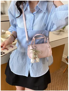 Detailed view of women pink mini pillow shoulder bag with cute pearl tulip pendant and strap.