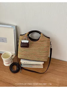 Detailed view of a vintage woven crossbody bag with leather handle and cute mini bag charm.