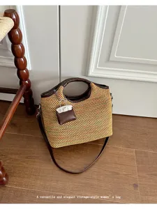 Chic woven bucket bag with leather handle and mini charm, stylish retro shoulder bag.