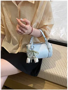 Light blue cylindrical pillow shoulder bag featuring elegant pearl and tulip pendant details.