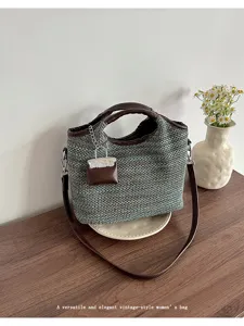 Detailed view of the stylish woven bucket shoulder bag featuring chic leather trim and charm.
