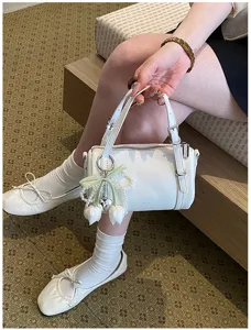 White fashion pillow shoulder bag detail view with cute pearl tulip charm and zipper design.