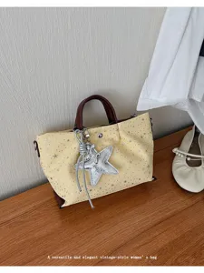 Close-up detail of the yellow star canvas shoulder bag featuring a chic silver star pendant.