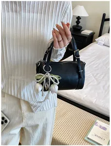 Detailed closeup view of stylish black small pillow shoulder bag with pearl tulip charm.