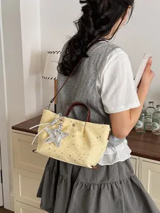 Trendy yellow star print tote bag with brown handles and chic star pendant for women.