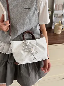 Fashionable contrast color tote shoulder bag with star pattern and cute metal charms for women.
