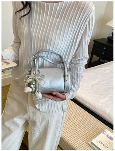 Silver pillow crossbody bag with pearl tulip pendant, stylish women mini shoulder bag detail.