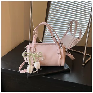 Pink pillow shoulder bag detail featuring sweet tulip pendant and stylish handle for daily wear.