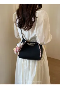 Stylish women's contrast woven bucket bag with metal lock and cute bear pendant for daily use.