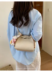Detailed view of the women's contrast stitching litchi pattern bucket crossbody bag.