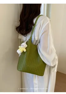 Green woven leather shoulder bag with cute bear pendant, stylish daily commute tote bag.