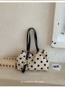 Detail view of a chic beige and black polka dot shoulder tote bag with a cute palm tree charm.