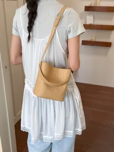 Stylish woven bucket bag for women, chic crossbody shoulder handbag with top handle.