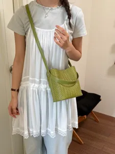 Stylish green woven bucket bag for women, trendy leather crossbody and shoulder handbag accessory.