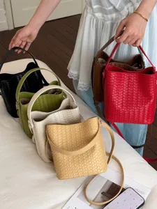 Stylish woven bucket bag with top handle and crossbody strap, multi-color fashion handbag.
