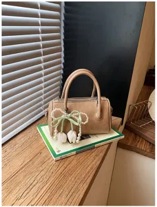 Detail view of the chic khaki pillow bag featuring an elegant pearl tulip charm and zipper.