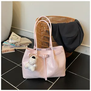 Detailed shot of pink woven tote bag with cute dog pendant, showcasing large capacity and elegant design.