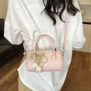 Chic pink barrel shoulder bag for women, trendy summer crossbody bag with pearl and floral charm.