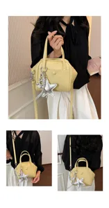 Detailed view of the stylish yellow shoulder bag with metallic silver star charm and soft texture.