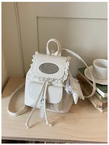 White leather backpack with sweet lace trim, stylish drawstring and metal badge detail.