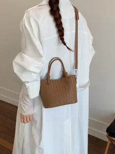 Retro brown woven leather crossbody bag for women, stylish daily handbag with top handle.